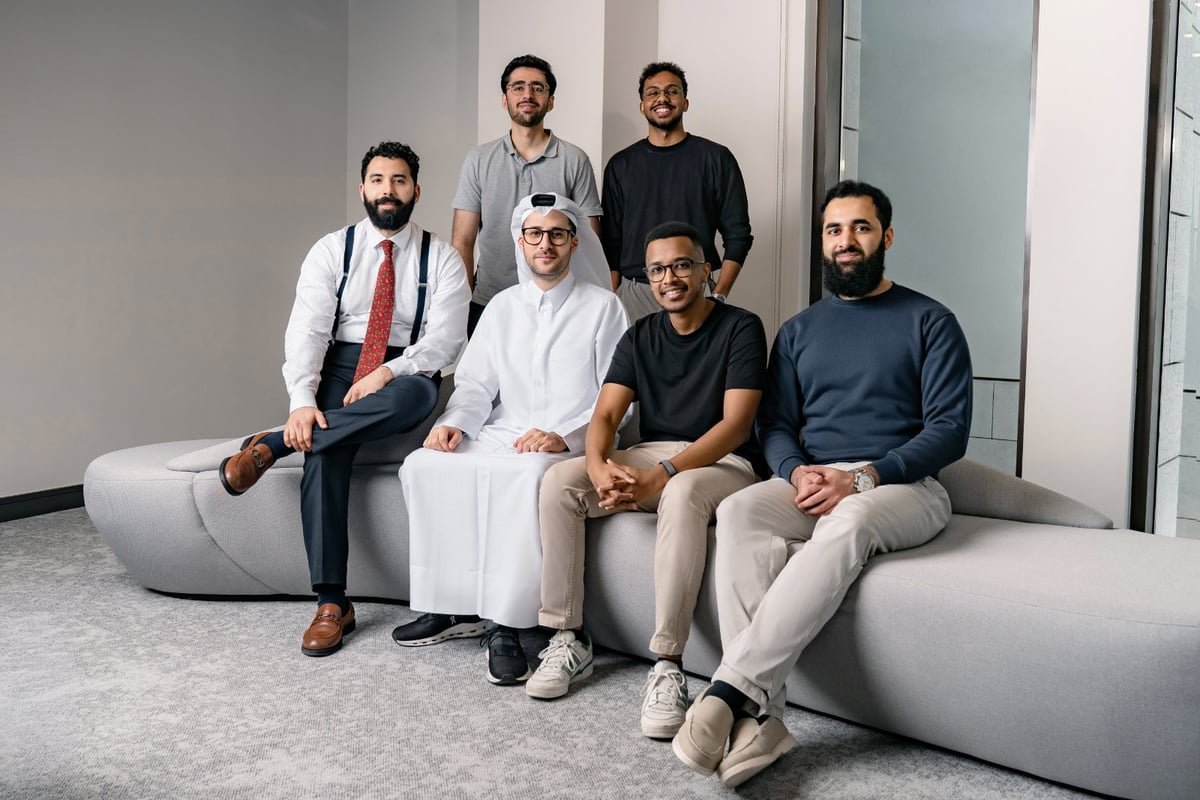 Six members of the Aligator team seated and standing together in a modern office.