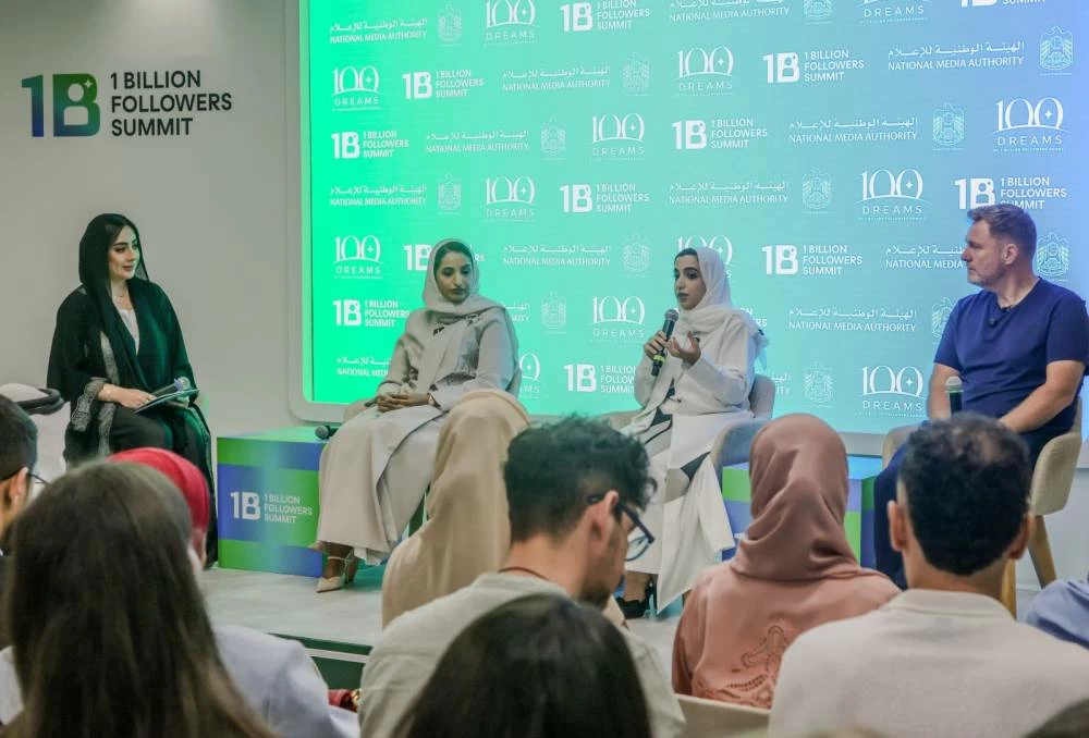 Audience watches the 100 Dreams launch press conference in Dubai, with Simon Squibb and officials seated on stage.